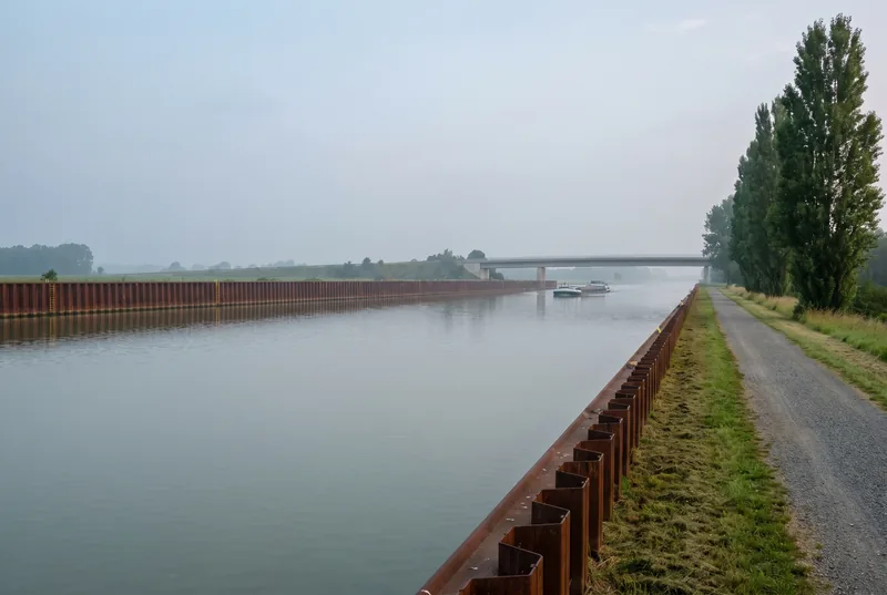 Schifffahrtskanal mit Spundwand und Pappelreihe am Morgen